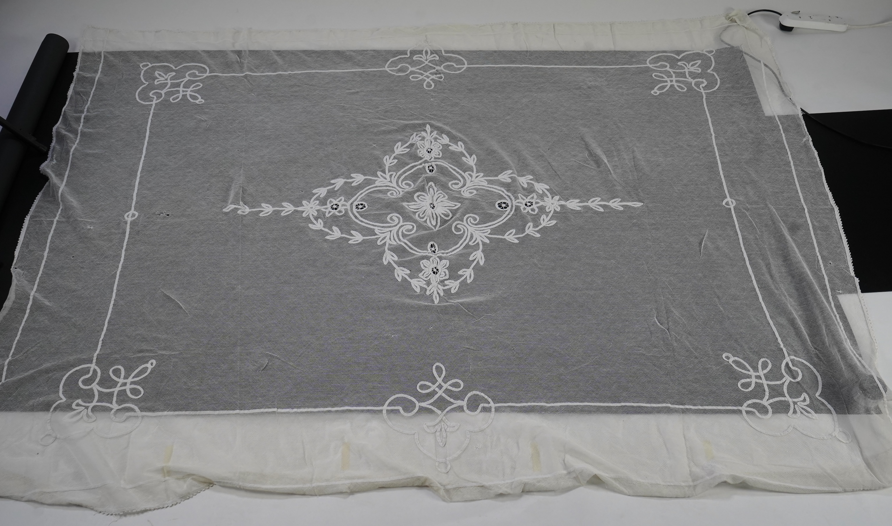 A white tape lace on net bed cover, a cream lace needle run panel, three Brussels bobbin lace collars, a lappet and two beaded tea pot covers, bed cover 200cm x 250cm. Condition - the bedcover has damage to the netting,